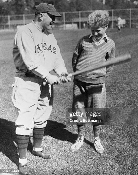 Joe McCarthy, manager of the Chicago Cubs, shows Bill Veeck the proper technique for holding a baseball bat during the Cubs' spring training.