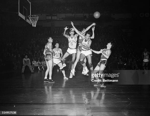 New York: Leo Gottleib and Ralph Kaplowitz of the Knicks, and Harold Brown of the Falcons, reach high for the rebound ball as Tom King of the Falcons...