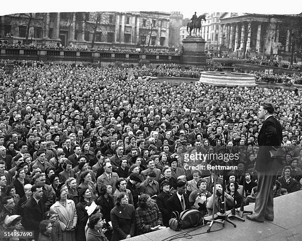 Bible in hand, American evangelist Billy Graham speaks to a crowd of intent listeners packing London's Trafalgar Square. In England on an extreme...