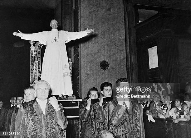 This unusual photo shows Pope Pius XII standing before his gestatorial chair as he is carried into one of the Vatican's apostolic halls to bless...