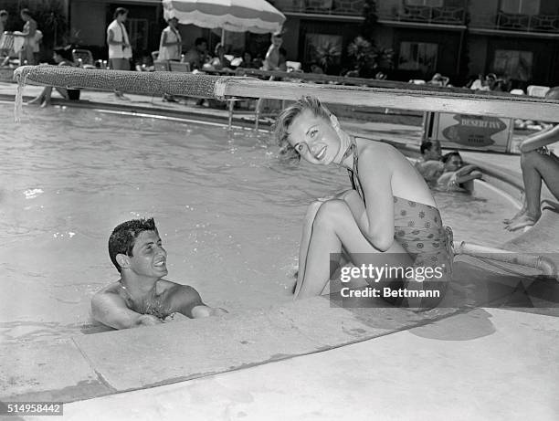 Get Along "Swimmingly"...Hollywood actress Debbie Reynolds, seated at the edge of a Las Vegas, Nevada, pool, casts a coy glance while singer Eddie...