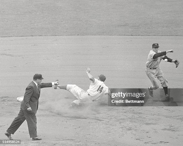 Dodgers' Gil Hodges slides into the sack but is called out by umpire Jocko Conlon as giant shortstop Alvin Dark wings the ball back to first for the...