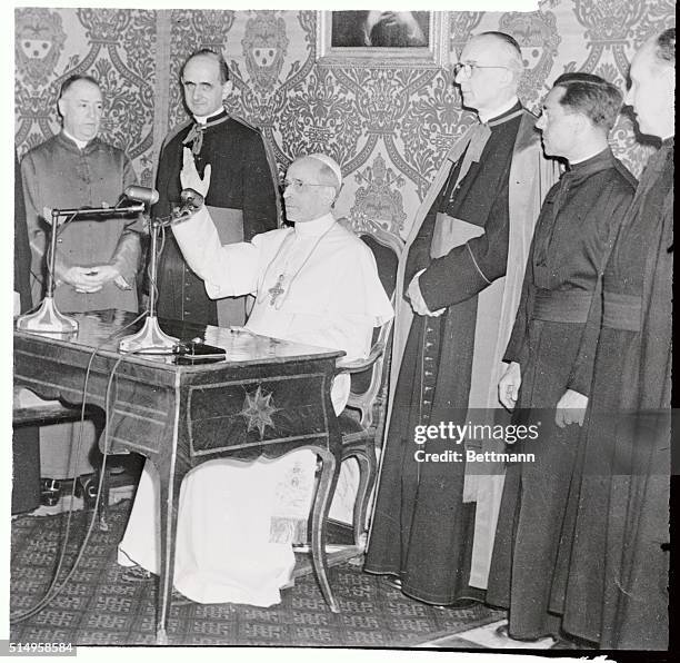 Pope Pius XII gestures the as he makes a direct radio broadcast from his summer residence in Castel Gondolfo to the Catholics of Canada. The...