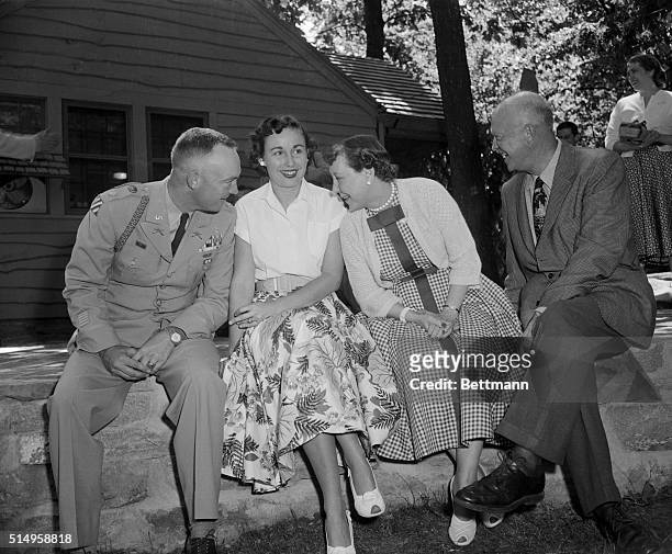 Mrs. Eisenhower, the First Lady, leans over for a work with her son, Major John Eisenhower, as the First Family enjoys an outing at Camp David, the...