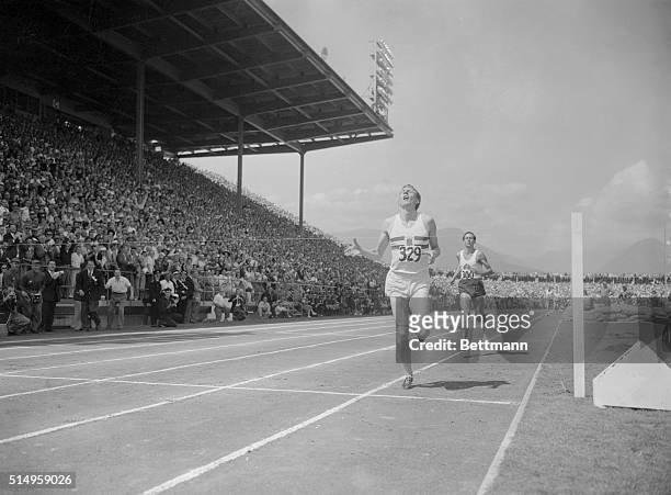 England's Dr. Roger Bannister , breaks the tape in the one-mile final at the British Empire Games in Vancouver, 8/7. Close behind is Australia's John...
