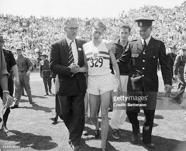 England's Dr. Roger Bannister, , is escorted from the field here after winning the mile race in the British Empire Games at Vancouver. Bannister's...