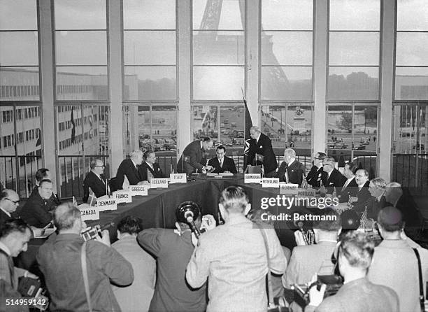 Foreign ministers from NATO counties look on as Pierre Mendes-France, French foreign minister, signs the treaties making West Germany a part of NATO....