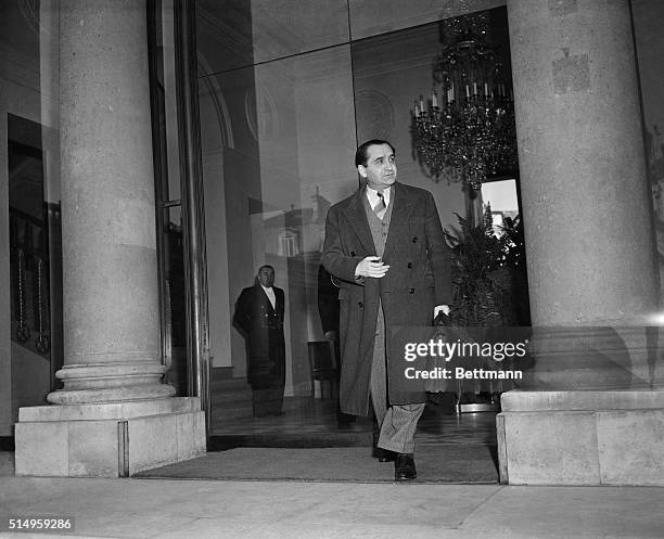 Briefcase in hand, a troubled French Premier Pierre Mendes-France leaves the Elysee Palace after a Cabinet meeting called to discuss the Algerian...