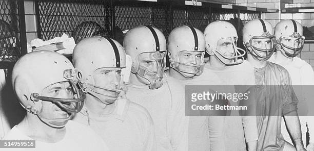 Members of the pro football Pittsburgh Steelers became "men from Mars" as they don special helmets to project their faces from injuries here. Left to...
