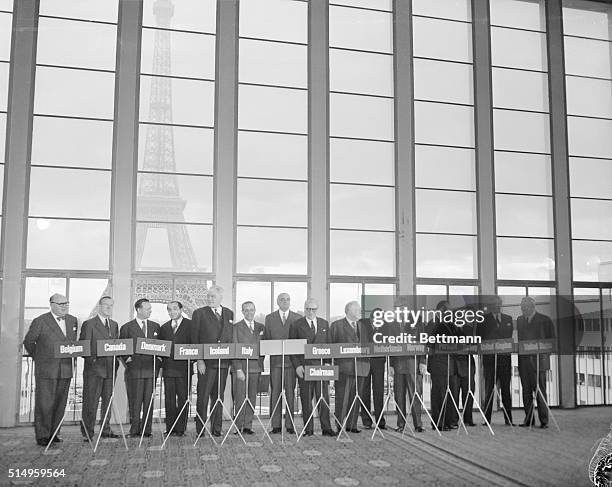 Ministers and delegates to the 14 nation NATO council pose in front of the Eiffel Tower before the opening of the meeting on Germany, at the Palais...