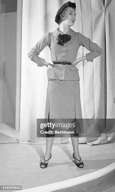 The simple, school girl look takes on smart airs at the hands of Chanel in this two-piece grey-blue wool jersey dress. The bodice is flattened, but...