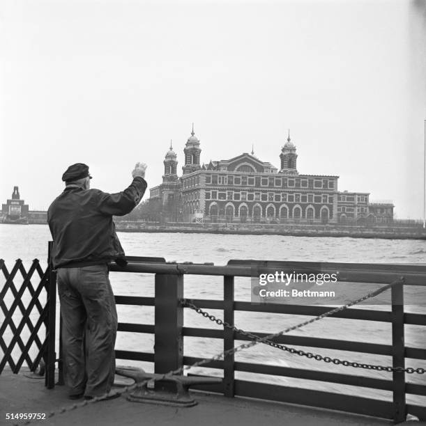 An employee who had worked for the U. S. Immigration Service for 30 years waves goodbye to Ellis Island, as the last ferry pulled out November 12th....
