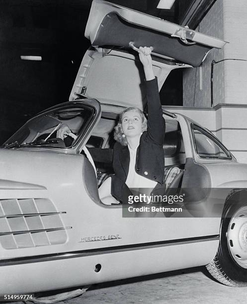 Lovely Geraldine Butler demonstrates the folding top on the Mercedes-Benz 300SL as the London Auto Show at Earls Court opens. Door and hood are...