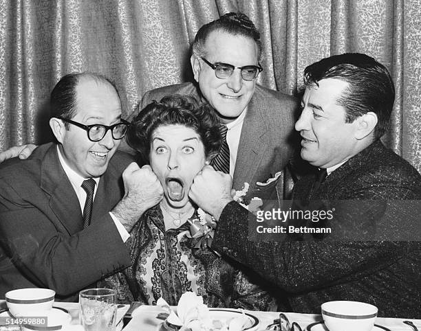 Getting the punchline...New York: Comedienne Martha Raye is amiably punched on the cheeks by comedy star Phil Silvers and former middleweight boxing...
