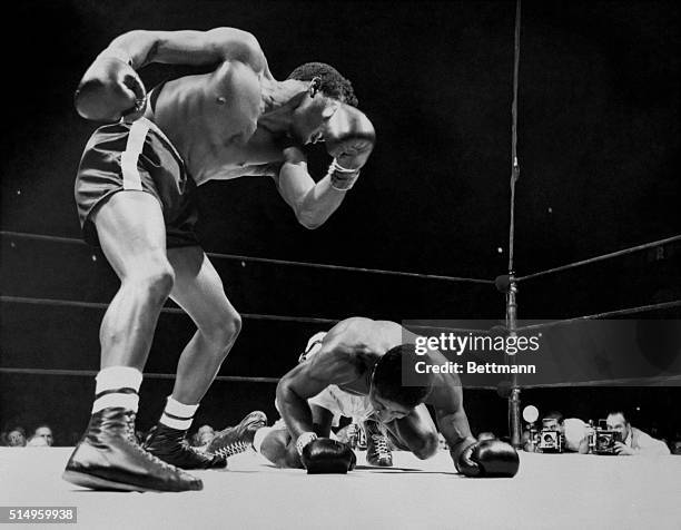 Floyd Patterson, young Light-heavyweight contender from Brooklyn, N.Y., gazes down at Jimmy Slade after flooring the New York Heavyweight contender...