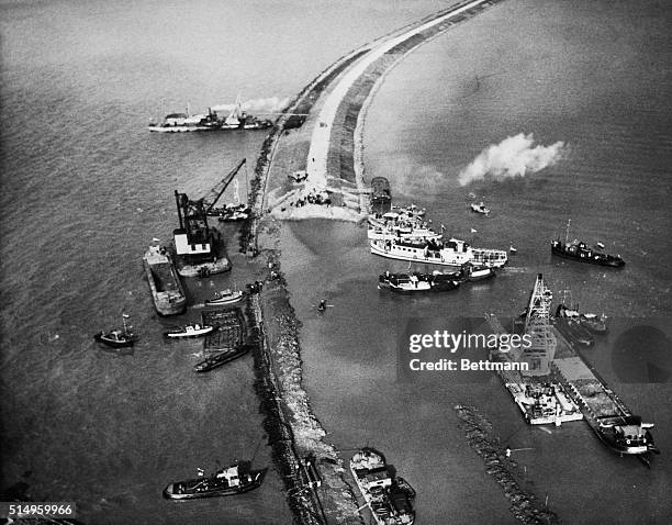 This aerial view shows operations when sea going cranes dumped earth to fill the last gap in a new dyke, closing off he sea from what will be new...