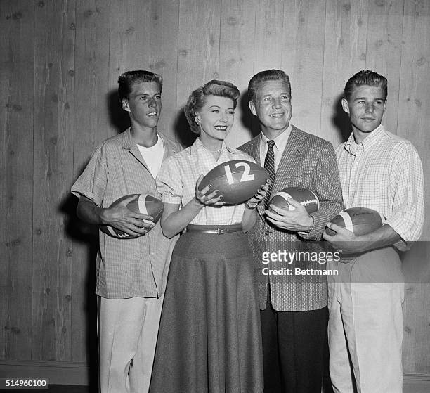 An Even Dozen. Hollywood, California: Ozzie and Harriet Nelson and their two sons prepare to kick off a pigskin to celebrate the 12th anniversary of...