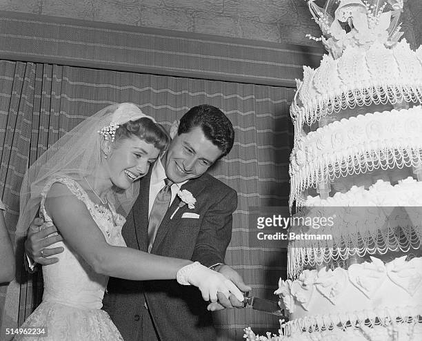 Liberty, NY- Actress Debbie Reynolds and singer Eddie Fisher cut their towering wedding cake after they were married at Liberty, NY. Their much...
