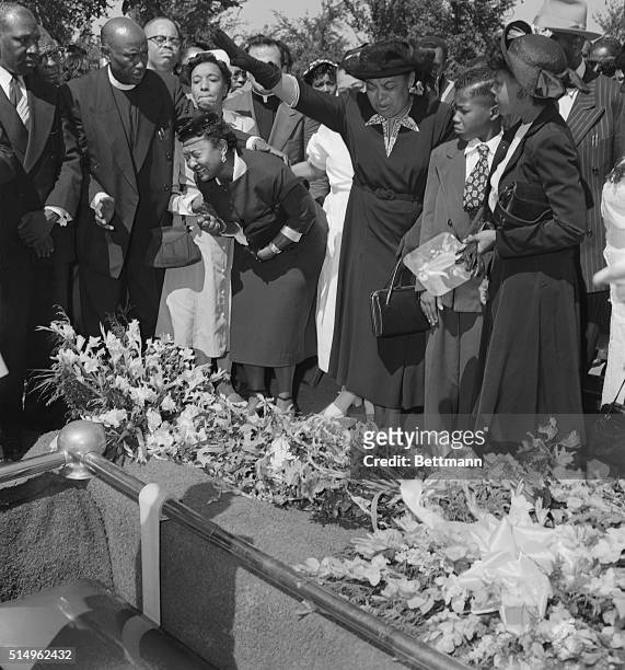 Friends restrain grief-stricken Mrs. Mamie Bradley as her son's body is lowered into the grave after a four day, open casket funeral. The 15-year old...