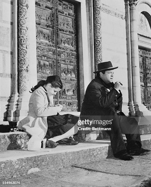 Actor Orson Welles sits meditatively on the steps of Pisa's Duomo as his daughter Rebecca appears engrossed in something on her lap. The two had a...