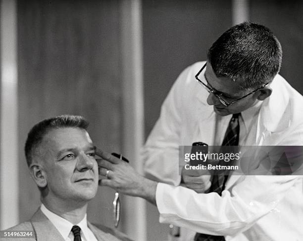 Dr. Harry L. Williams examines the eyes of Dr. Carl Pfeiffer after administering LSD 25, the new drug which produces effects similar to those...