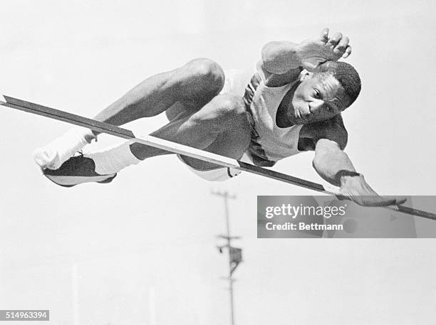 All-American basketball center, Bill Russell, shows his rare form as he clears the high jump bar at six feet, eight inches in the University of San...