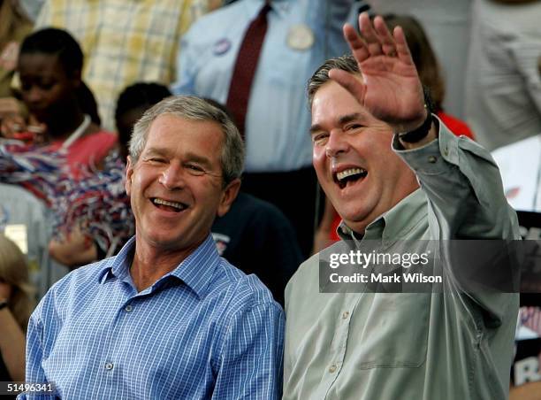 President George W. Bush and his brother Florida Governor Jeb Bush smile while greeting supporters during a campaign rally at Progress Energy Park...