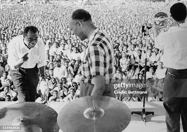 "Satchmo" jazzes up Africa. Accra, Gold Coast: Louis "Satchmo" Armstrong whoops it up with Edmund Hall and "Trummy" Young for a huge crowd at Accra,...