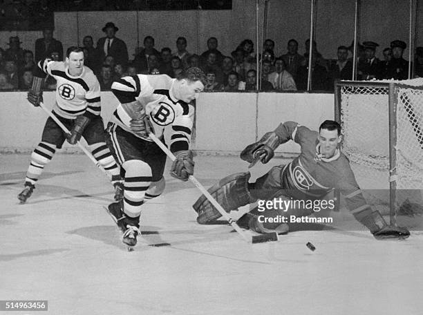 Montreal Canadiens goalie Jacques Plante , knocks out a shot fired by Boston Bruins player Vic Stasiuk during the first period of a hockey game held...