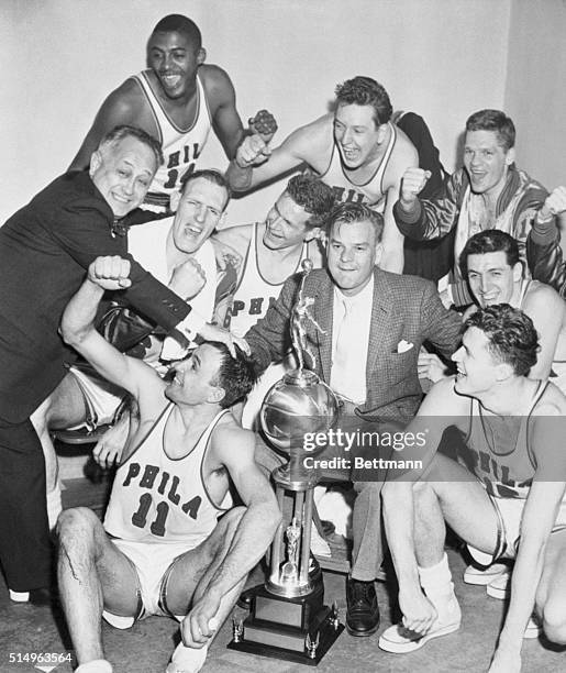 Dressing room shot after the Warriors after winning the championship with George Senesky holding the trophy and Eddie Gottlieb congratulating the...