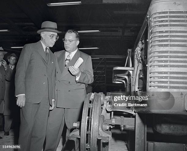 Prime Minister Pandit Nehru, of India, touring the United States, listens intently as he receives information concerning farm tractors from works...