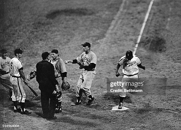 Dodger Jackie Robinson is shown crossing home plate in the 8th inning of this Dodger-Chicago game, as members of the Chicago Cubs rush in to argue...