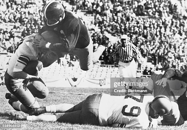 Dallas, TX- TCU halfback, Jim Swink, puts a diving headlock on Syracuse's Fred Kuczala, who picked up three yards late in the second quarter of the...