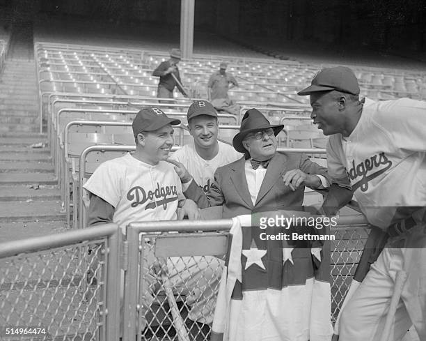 Branch Rickey, President of the Brooklyn Dodgers, is shown with three of his stars, as they invaded the Yankee stadium today for a pre-series workout...