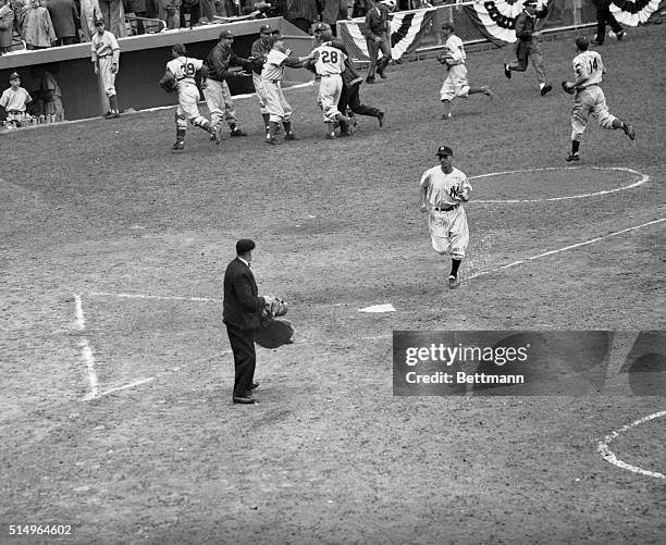 While wildly enthusiastic Brooklyn Dodgers grab their victorious hurler Preacher Roe in background to thump his back and congratulate him on his...