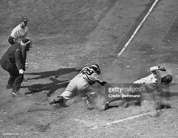 Fleet Jackie Robinson of the Brooklyn Dodgers beats the ball home, and in spite of all of catcher silvers of the Yankees, reaching for the ball is...