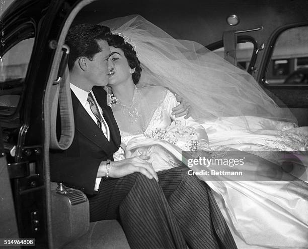 Actress Elizabeth Taylor kisses her groom, Conrad "Nickie" Hilton, Jr. In the limousine that will take them to their wedding reception at the Bel-Air...