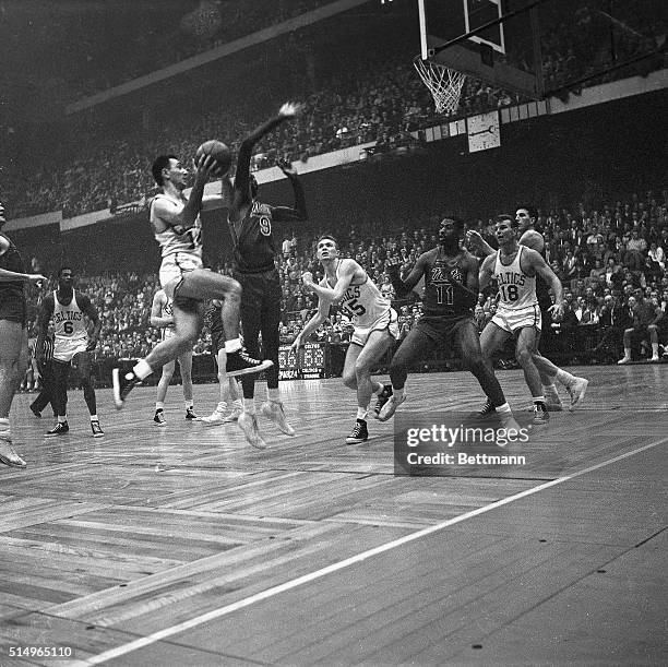 Celtics' Bob Cousy drives in hard past the guard of Nats' Bob Hopkins to make the two-hand lay up shot as Celts' Tom Heinsohn, Nats' Earl Lloyd,...