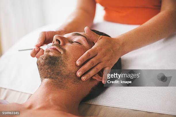 man getting a face treament at the health spa - facial spa treatment stock pictures, royalty-free photos & images