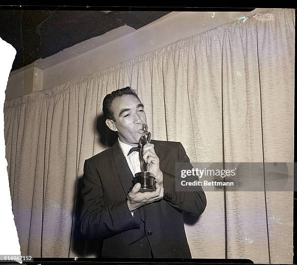 Hollywood, CA- Actor Anthony Quinn kisses his Oscar March 27th after he was honored as "Best Supporting Actor" for his role in "Lust for Life"....