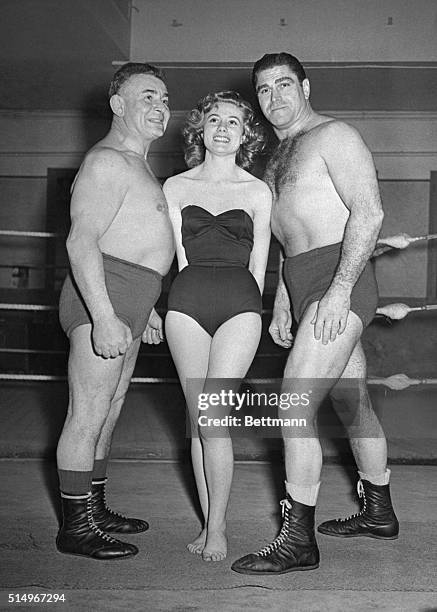 Paris, France: Miss France Meets A Wrestling Duo...The newly elected Miss France, Maryse Delort , is shown with wrestlers Sexton , and Henri Declane,...