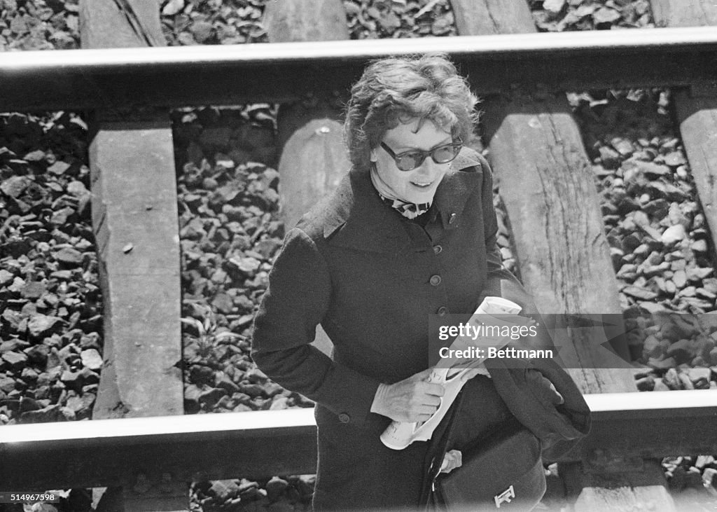 Actress Greta Garbo Pausing by Railroad Tracks