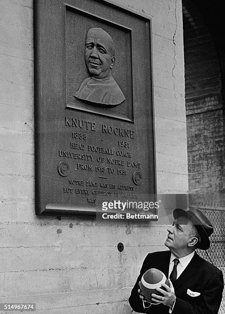 Looking up at the most celebrated football coach of all time, actor Pat O'Brien stops at the memorial plaque to Knute Rockne of Notre Dame in the Los...