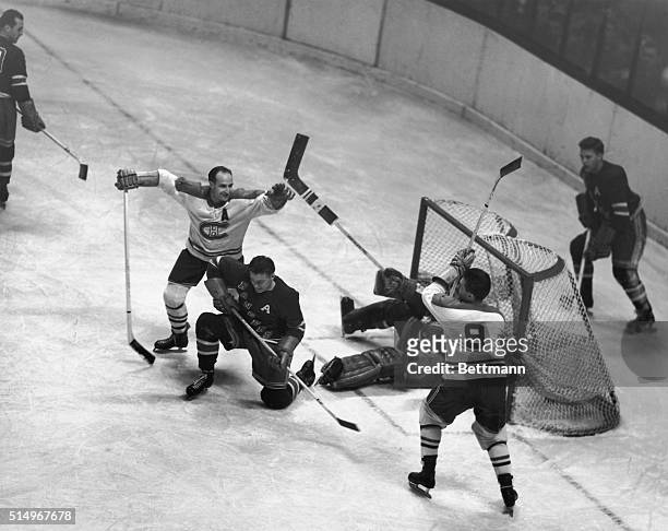 Maurice Richard , of the Montreal Canadiens, has just rammed the puck past goalie Chuck Rayner of the New York Rangers for a score during the first...