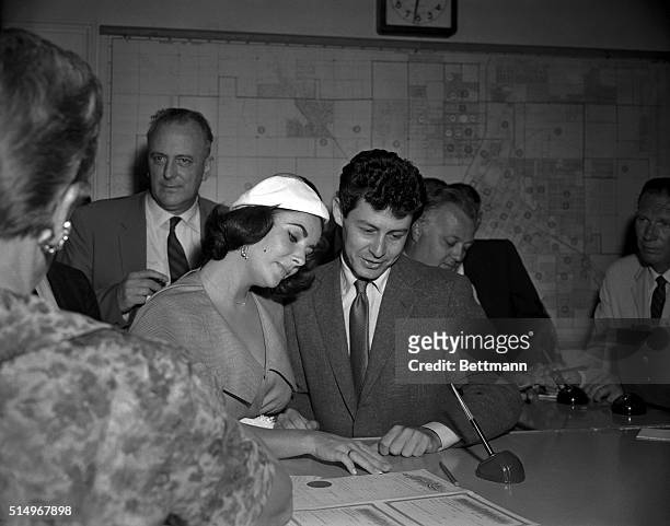 Las Vegas, Nevada- Elizabeth Taylor and Eddie Fisher gaze at their marriage license which they obtained right after Fisher was granted a divorce from...
