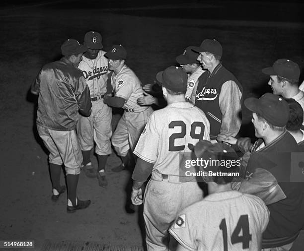 After clouting a homer in the 4th inning of this crucial game against the Philadelphia Phillies, Jackie Robinson of the Brooklyn Dodgers is greeted...