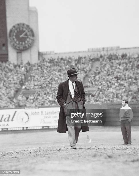 Photo shows Paul Brown, Head Coach of the CLeveland Browns, walking on a football field.