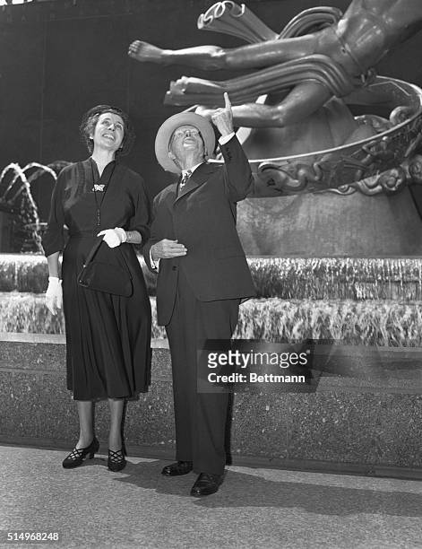 John D. Rockefeller, Jr. Is shown as he pointed with pride to a feature of Rockfeller Center as he took his bride, the former Mrs. Martha Baird...