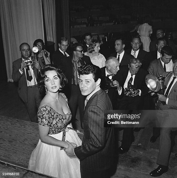 Las Vegas: Elizabeth Taylor and Eddie Fisher hold hands as they leave the Tropicana Night Club here, May 11th, where Fisher has been performing for...