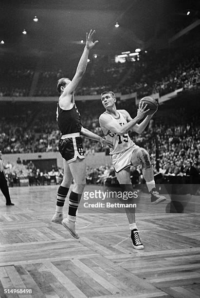 Boston: Tom Heinsohn of the Boston Celtics eyes basket as he goes up with a left hand hook shot over the outstretched arm of Vern Mikkelson of the...